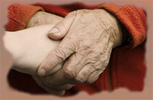 Older persons's hands holding younger persons's hands representing care and compassion of hospice volunteers